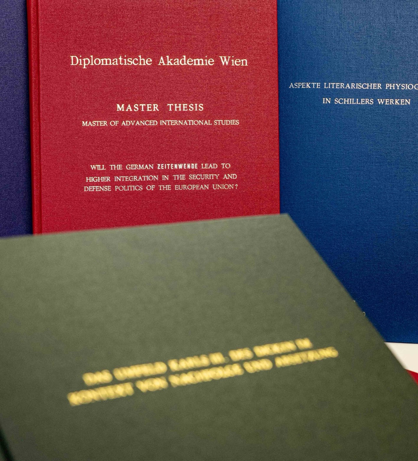 Thèses et mémoires reliés en Buckram (rouge, bleu, vert) aux finitions dorées — atelier Köller-Willems